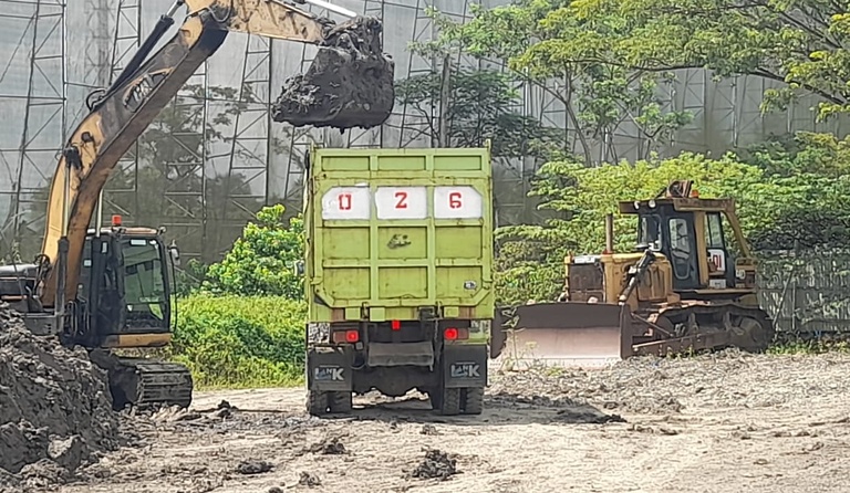 Aktivitas pembuangan lumpur di area stockpile menggunakan excavator dan dump truck oleh tim PT Sarindo Utama Teknik