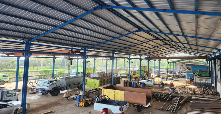 Workshop 3 PT Sarindo Utama Teknik – area fabrikasi dan maintenance unit industri dengan overhead crane dan aktivitas perbaikan armada